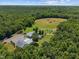 Expansive aerial view of a private estate featuring a home, garages, outbuildings and lush surrounding forest at 4050 Culbreth Rd, Stem, NC 27581