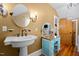 Bathroom featuring a pedestal sink, vanity with mirror, and a decorative faucet, adding to its vintage charm at 4050 Culbreth Rd, Stem, NC 27581