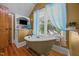 Bathroom featuring a freestanding tub with fixtures, blue curtains, and built-in shelving for a relaxing atmosphere at 4050 Culbreth Rd, Stem, NC 27581