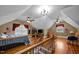 Open bonus room area with hardwood floors, a bed, a sitting area, and dormer windows at 4050 Culbreth Rd, Stem, NC 27581