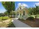 Charming cottage with a covered porch, complemented by a green chairs and a well-manicured lawn at 4050 Culbreth Rd, Stem, NC 27581
