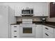 Bright kitchen equipped with white appliances and countertops and wooden cabinets at 4050 Culbreth Rd, Stem, NC 27581