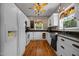 Bright kitchen featuring white cabinetry, black countertops, hardwood floors, and modern appliances at 4050 Culbreth Rd, Stem, NC 27581