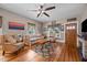Inviting living room features hardwood floors, a ceiling fan, and a decorative fireplace at 4050 Culbreth Rd, Stem, NC 27581