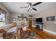 Cozy living room features hardwood floors, a ceiling fan, and a stone fireplace at 4050 Culbreth Rd, Stem, NC 27581