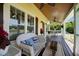 Inviting porch with wicker furniture, wooden ceiling and views, perfect for relaxing and enjoying the outdoors at 4050 Culbreth Rd, Stem, NC 27581