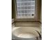 Close-up of a soaking tub featuring a decorative glass block window at 421 Braxman Ln, Holly Springs, NC 27540