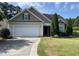 Charming home showcasing a tan exterior, attached garage, manicured lawn and mature trees at 421 Braxman Ln, Holly Springs, NC 27540