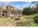 Spacious backyard featuring a brick patio, outdoor seating, a built-in fire pit, and mature trees at 4228 Fawn Lily Dr, Wake Forest, NC 27587