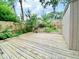 Landscaped backyard featuring wooden deck, privacy fence, mature trees, garden beds, and a storage shed at 4324 Halliwell Dr, Raleigh, NC 27606