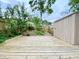 Landscaped backyard with a wooden deck, privacy fence, mature trees, and storage shed at 4324 Halliwell Dr, Raleigh, NC 27606