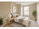 This virtually staged bedroom features a double bed, simple art, a houseplant, and a window at 4324 Halliwell Dr, Raleigh, NC 27606