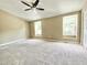 Spacious carpeted bedroom with neutral walls, ceiling fan, and abundant natural light from two large windows at 4324 Halliwell Dr, Raleigh, NC 27606