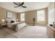 Virtually staged bedroom with neutral walls, ceiling fan, and abundant natural light from two large windows at 4324 Halliwell Dr, Raleigh, NC 27606