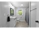 Bathroom with gray walls, vinyl floors, and vanity with black framed mirror at 437 Woodsdale Rd, Roxboro, NC 27573