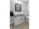 Bathroom vanity with a white sink, a black framed mirror, and a sliding door at 437 Woodsdale Rd, Roxboro, NC 27573