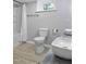 Bright bathroom features a shower with curtain, toilet, and double sinks with neutral decor at 437 Woodsdale Rd, Roxboro, NC 27573