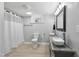 Basement bathroom features a double sink vanity, toilet, and shower with a curtain at 437 Woodsdale Rd, Roxboro, NC 27573