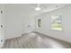 Bright bedroom with gray vinyl floors, white walls, and natural light at 437 Woodsdale Rd, Roxboro, NC 27573