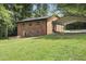 Two-story brick home with a well-manicured lawn, brick patio, and carport providing convenient parking at 437 Woodsdale Rd, Roxboro, NC 27573