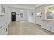 Bright open space with a black front door, white trim, and gray vinyl flooring at 437 Woodsdale Rd, Roxboro, NC 27573