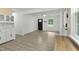 Open-concept living room with gray vinyl floors, white walls, and plenty of natural light at 437 Woodsdale Rd, Roxboro, NC 27573