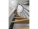Looking up at a spiral staircase featuring hardwood steps, a black metal railing, and white trim at 437 Woodsdale Rd, Roxboro, NC 27573