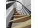 Low angle image looking up at a spiral staircase with hardwood steps and a black metal handrail at 437 Woodsdale Rd, Roxboro, NC 27573