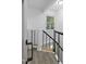 A stairway with gray wood-look floors and a white railing with black, decorative metal bars at 437 Woodsdale Rd, Roxboro, NC 27573