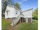 Back of house showing deck access, brick foundation, grassy yard, and storage area at 448 Chinaberry Ln, Angier, NC 27501