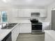 Well-lit kitchen featuring updated appliances, ample counter space, and white cabinetry at 448 Chinaberry Ln, Angier, NC 27501