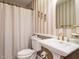 Classic bathroom featuring a pedestal sink, toilet, and a shower with neutral-colored wallpaper at 45 Softwood Dr, Franklinton, NC 27525