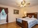 Cozy bedroom with wood-frame bed, complemented by a ceiling fan and abundant natural light from the window at 45 Softwood Dr, Franklinton, NC 27525