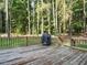 Spacious deck with wooden railings and a grill, surrounded by tall trees, perfect for outdoor enjoyment at 45 Softwood Dr, Franklinton, NC 27525