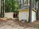 Exterior view of outbuilding with a ramp, located on a wooded lot, providing additional storage and workspace at 45 Softwood Dr, Franklinton, NC 27525