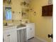 Vintage bathroom with double sinks, storage, and yellow walls at 462 Ashland Dr, Goldston, NC 27252