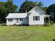 Exterior shot of the home with white siding and a large yard at 462 Ashland Dr, Goldston, NC 27252