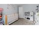 Well-lit room with a wooden crib and floral decorations on the light blue walls at 51 Brafford Estates Dr, Cameron, NC 28326