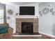 Close-up of a charming stone fireplace with a decorative mantel and a TV mounted above at 51 Brafford Estates Dr, Cameron, NC 28326