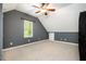 Attic bonus room features vaulted ceilings, neutral carpet and gray accent wall with a single window at 5113 Linksland Dr, Holly Springs, NC 27540