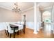 Dining room with wood floors, traditional columns, a view of the foyer and bright windows at 5113 Linksland Dr, Holly Springs, NC 27540