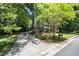 View of the home down a long driveway bordered by mature trees and well-manicured lawns at 5113 Linksland Dr, Holly Springs, NC 27540