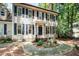 Traditional home with black shutters, a covered entry, and manicured garden at 5113 Linksland Dr, Holly Springs, NC 27540