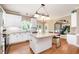 Well-lit kitchen boasts a center island with seating, white cabinets, and stainless steel appliances at 5113 Linksland Dr, Holly Springs, NC 27540