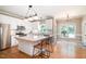 Bright kitchen features a large island, white cabinets, stainless steel appliances, and hardwood floors at 5113 Linksland Dr, Holly Springs, NC 27540