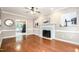 Cozy living room with hardwood floors, fireplace, and an open layout to other spaces at 5113 Linksland Dr, Holly Springs, NC 27540