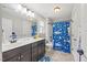 Stylish bathroom with dual sink vanity, large mirror, and a fun, patterned shower curtain, offering comfort and functionality at 512 Mill Hopper Ln, Apex, NC 27502
