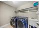 Well-equipped laundry room with modern washer and dryer, utility sink, and storage shelves at 512 Mill Hopper Ln, Apex, NC 27502