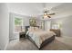 Serene main bedroom with soft carpet, ceiling fan, dresser, and abundant natural light from a window at 512 Mill Hopper Ln, Apex, NC 27502