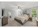 Serene main bedroom with soft carpet, ceiling fan, dresser, and abundant natural light from several windows at 512 Mill Hopper Ln, Apex, NC 27502